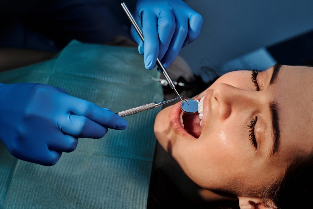 Close-up of a dentist examining a patient's teeth using dental tools.